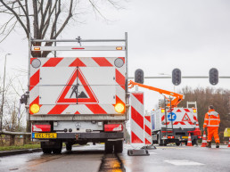 Verkeersmaatregelen van Versluys Verkeerstechniek tijdens wegwerkzaamheden op een kruispunt met afzettingen, signalering en verkeersregelaars.