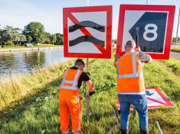 Medewerkers van Versluys Verkeerstechniek plaatsen scheepvaartborden en signalering langs een waterweg voor veilige doorvaart en verkeersbegeleiding.