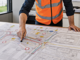 Werkvoorbereider van Versluys Verkeerstechniek wijst op een BLVC-verkeersplan met omleidingen voor auto, fiets, voetganger, OV en hulpdiensten